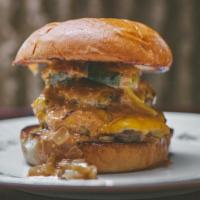 Homage Burger · double cheeseburger made with brisket and cured bacon, topped with caramelized onions, house...