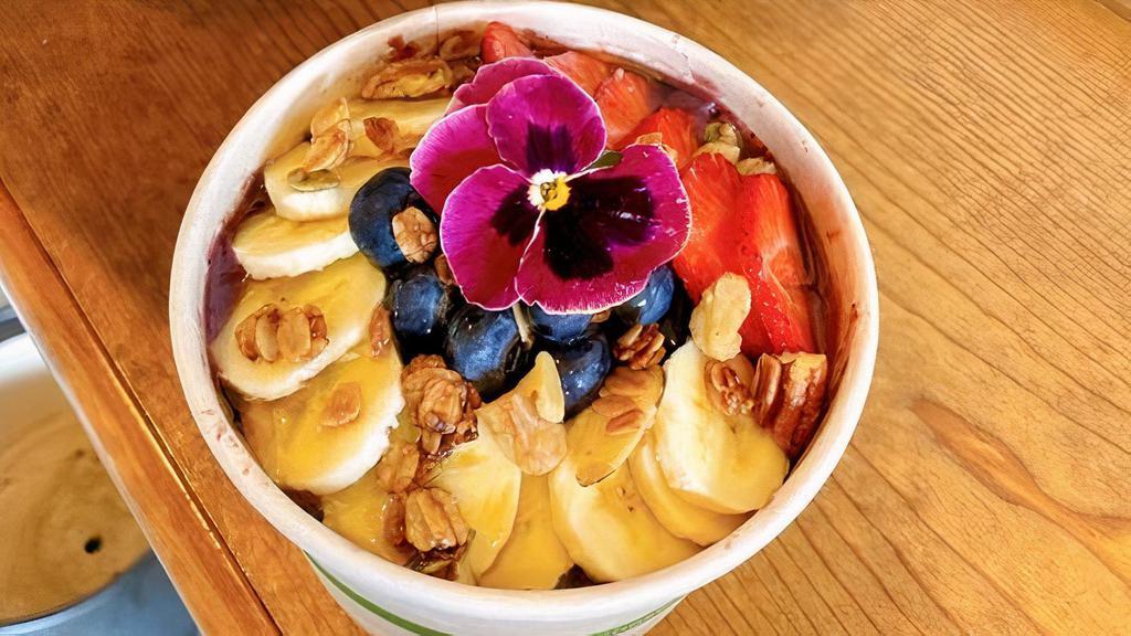 Acai Bowl · Homemade acai sorbet with a lot of organic acai puree.  Topped with our homemade roasted granola and fresh organic fruits. (Fresh organic strawberries, blueberries and bananas) With the choice of local raw honey or organic agave. Contains nuts.