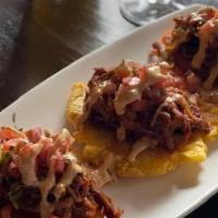 Tacos Patacon · fried plantains topped with slow-cooked pulled pork, 
pico de gallo & house poblano sauce