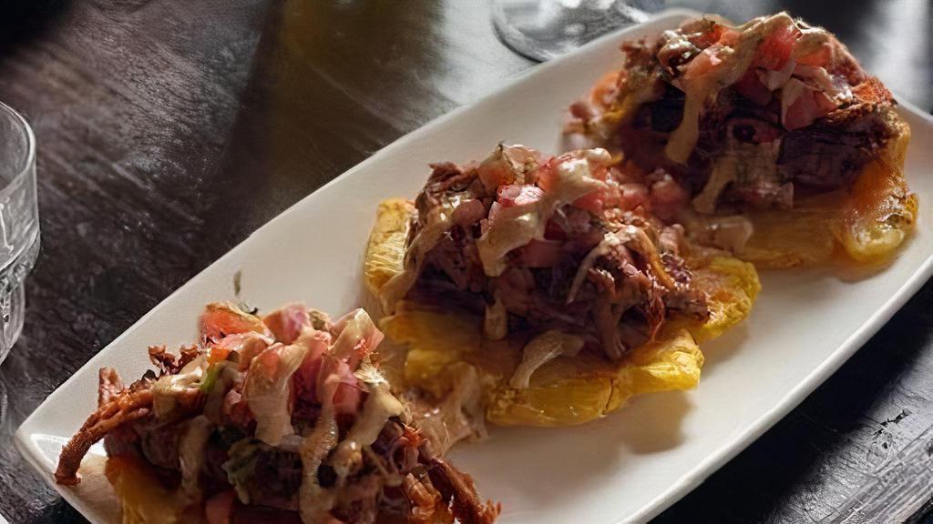Tacos Patacon · fried plantains topped with slow-cooked pulled pork, 
pico de gallo & house poblano sauce