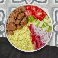 Lamb Gyro Over Rice · Exotic lamb meat slices topped on bed of rice with side of salad.
