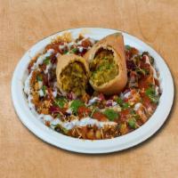 Samosa Reloaded · Authentic samosa smashed and topped with yogurt, mint, and tamarind sauce and sprinkled with...