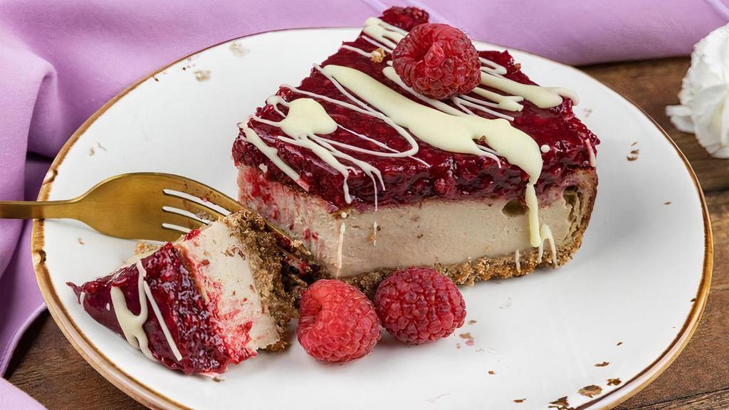 Raspberry White Chocolate Cheesecake (Gf) · graham cracker crust, white chocolate cheesecake, raspberry topping, fresh raspberries