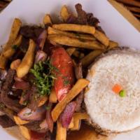 Lomo Saltado Carne · Traditional Peruvian stir-fry, seasoned strips of steak, onions, and tomatoes, served with c...