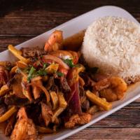 Saltado De Camarones · Traditional Peruvian stir-fry, with shrimps, red onions, and tomatoes. Served with French fr...