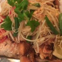 Whole Fish Red Snapper With Papaya Salad Sauce · Fried whole fish topped with green papaya, tomato, peanut and long bean in spicy lime dressi...