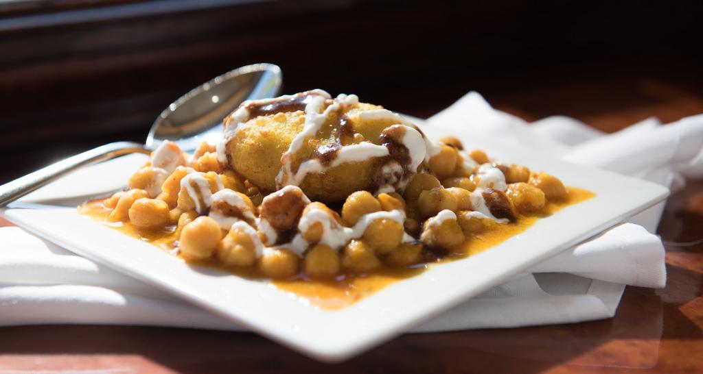 Aloo Tikki Chole · Pan fried potato cakes topped with curried chickpeas, yogurt and chutney.