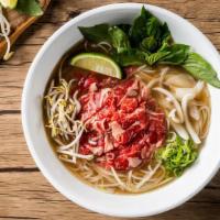 Classic Rare Beef Pho Noodle Soup · Rare beef with rice noodles, served with beef broth, onions, scallions, and lemon, basil & b...