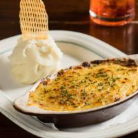 Chicons Au Gratin · Baked endive wrapped in ham, bechamel sauce, gratinated Swiss cheese, and mashed potatoes.