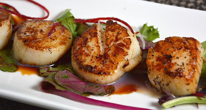 Grilled Sea Scallops · Grilled sea scallop with black pepper sauce.