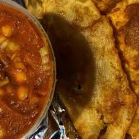 Chole Poori · A large puffy bread served with spicy chickpeas.