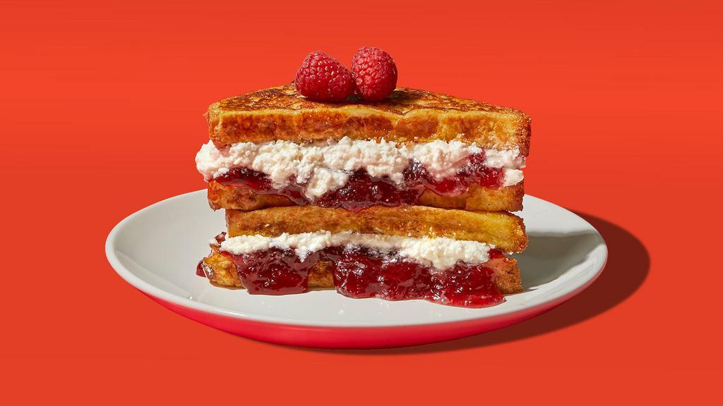 Ricotta Jelly Stuffed French Toast · Four slices of egg-washed french toast stuffed with ricotta and jelly and topped with maple syrup and butter.