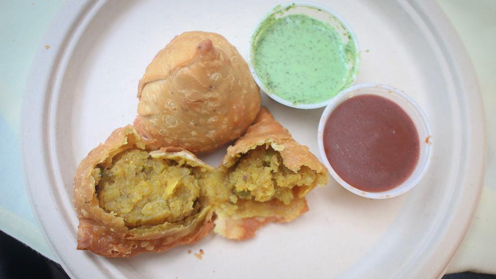 Samosa Chat · Vegetarian. Crispy pastry stuffed with spiced potatoes and peas topped with yogurt tamarind, mint and onion chutney.
