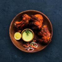 Tandoori Chicken · Chicken marinated in yogurt and herbs cooked in a traditional Indian clay oven.