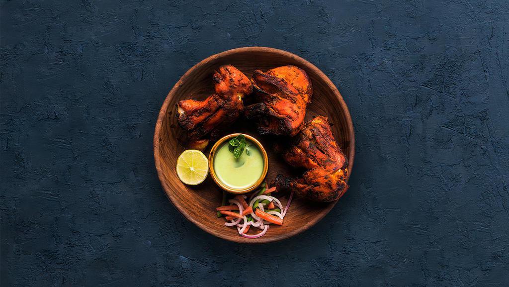 Tandoori Chicken · Chicken marinated in yogurt and herbs cooked in a traditional Indian clay oven.