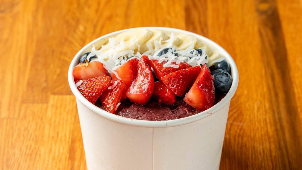 Acai Bowl · Blended acai with strawberries, banana and a splash of coconut milk. Topped with two layers of granola, strawberries, blueberries, banana, shredded coconut and a drizzle of honey.
