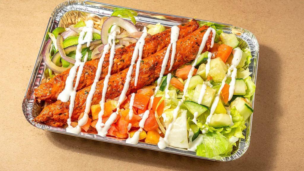 Kofta Kebab Over Rice · Kebab made with ground Chicken and herbs served over brown basmati rice with choice of salad and any of shahs sauces
