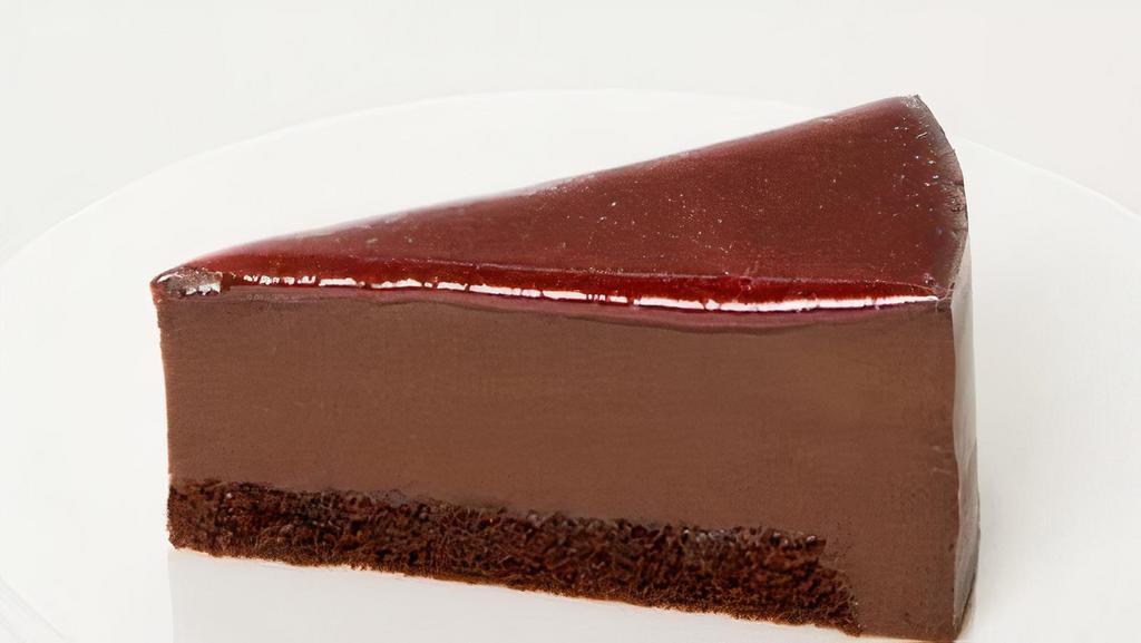 Framboise Au Chocolat · Dense chocolate mousse atop a thin layer of raspberry compote and chocolate sponge. Finished with ganache and raspberry gelee.