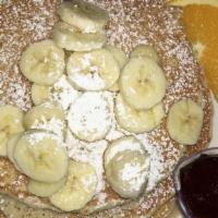 Banana Cakes · Pancakes cooked with banana slices and topped with fresh banana slices and cream. Served wit...
