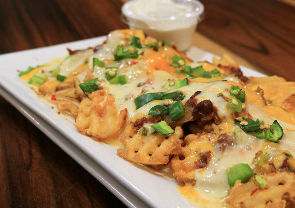 Ssd Nachos · Crispy waffle fries topped with beef chili, melted jack, and cheddar cheese, topped with sour cream and jalapenos.
