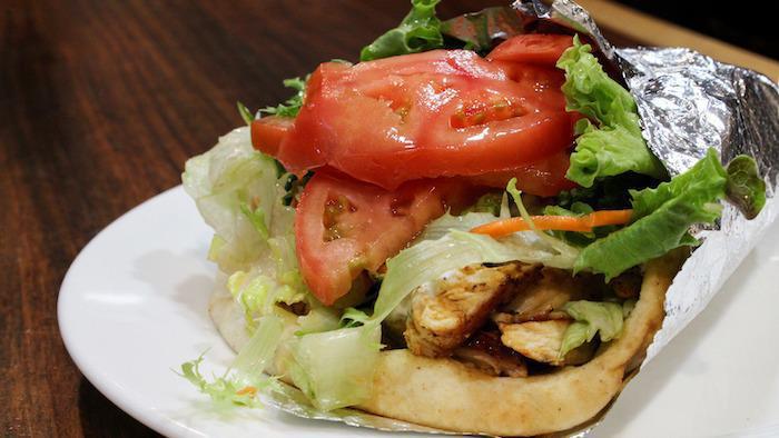Chicken Souvlaki Sandwich · Pieces of marinated grilled chicken on a hot pita with lettuce, tomato, onions and white sauce.