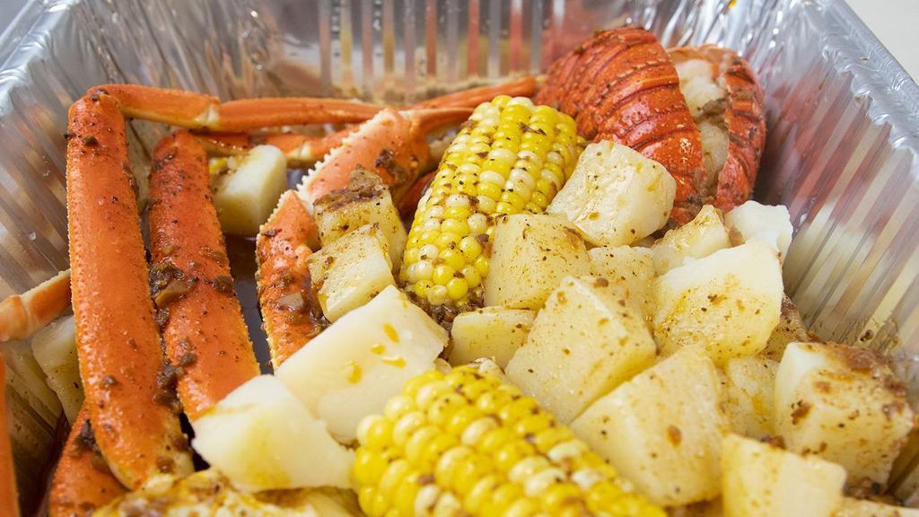 Lobster Tail & Snow Crab Legs W/ Potatoes And Corn · comes with potatoes corn & Cajun  sauce