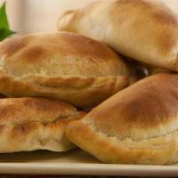 Family Package 1 · 6 empanadas served with choice of 2 sides of rice and beans, 3 canned soda, 2 dessert empana...
