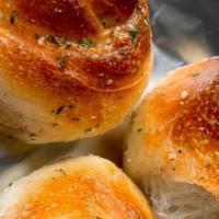 Garlic Knots (Dozen) · Knots of Pizza Dough coated with Olive Oil infused with Garlic, Parsley, and Parmesan