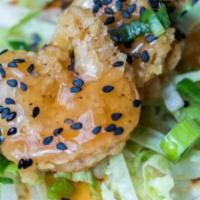 Kung Pao Shrimp Taco · Breaded shrimp tossed in an Asian sweet and sour sauce with lettuce and black sesame seeds. ...