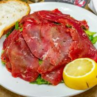 Carpaccio Bresaola · Air dried, spiced beef with rucola in a lemon mustard dressing.