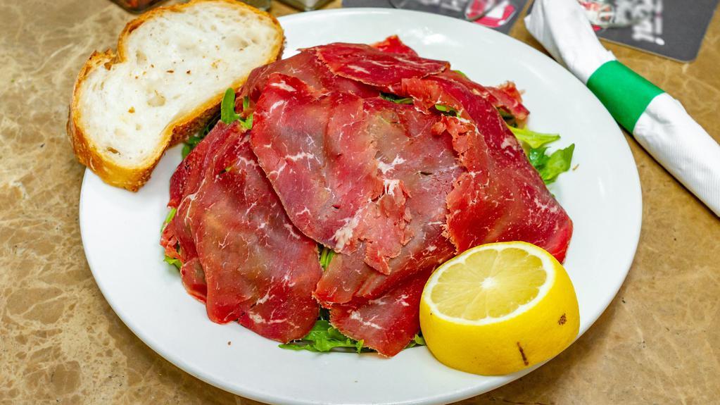 Carpaccio Bresaola · Air dried, spiced beef with rucola in a lemon mustard dressing.