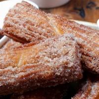 Churros · Dusted with sugar and cinnamon. Served with dark chocolate and raspberry-guajillo dipping sa...