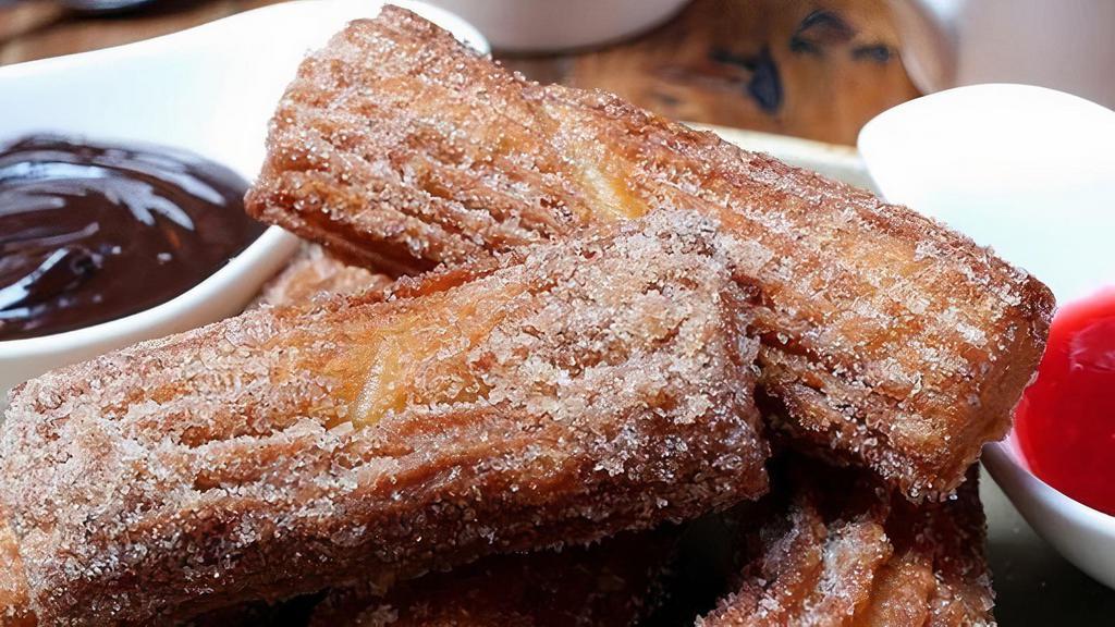 Churros · Dusted with sugar and cinnamon. Served with dark chocolate and raspberry-guajillo dipping sauces.