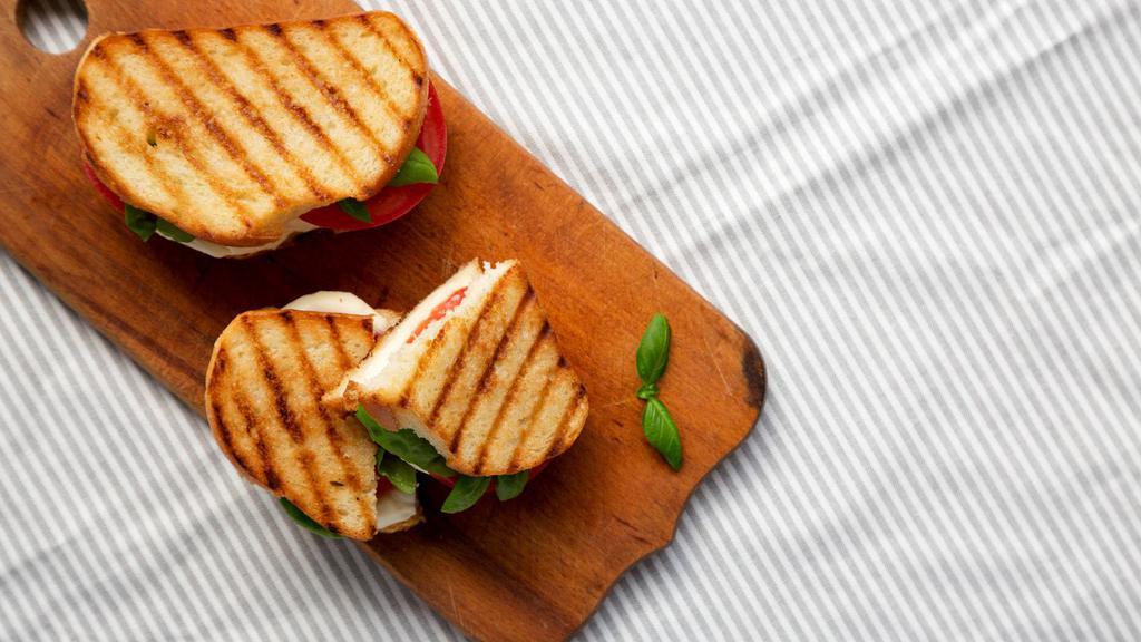 Mediterranean Panini · Crispy, buttery, pressed sandwich loaded with fresh spinach, tomatoes and roasted peppers, fresh mozzarella and basil pesto.