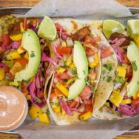Fish Tacos Costeños · Order of three fried tilapia tacos served on cilantro-lime coated flour tortillas, topped wi...