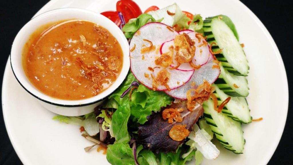 Thai Salad · Vegetarian. Gluten-free. Mixed green vegetables, romaine lettuce, tomatoes, and cucumber with peanut sauce dressing and topped with fried shallots.