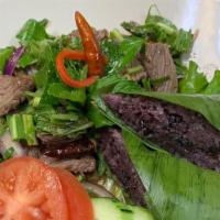 Nam Tok · Grilled sliced top Sirloin, chili powder, roasted rice powder, red onion and scallions, with...