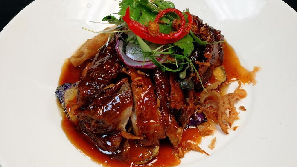 Duck Red Wine Tamarind · Crispy roasted duck topped with aromatic red wine tamarind reduction, garnished with fried shallots.