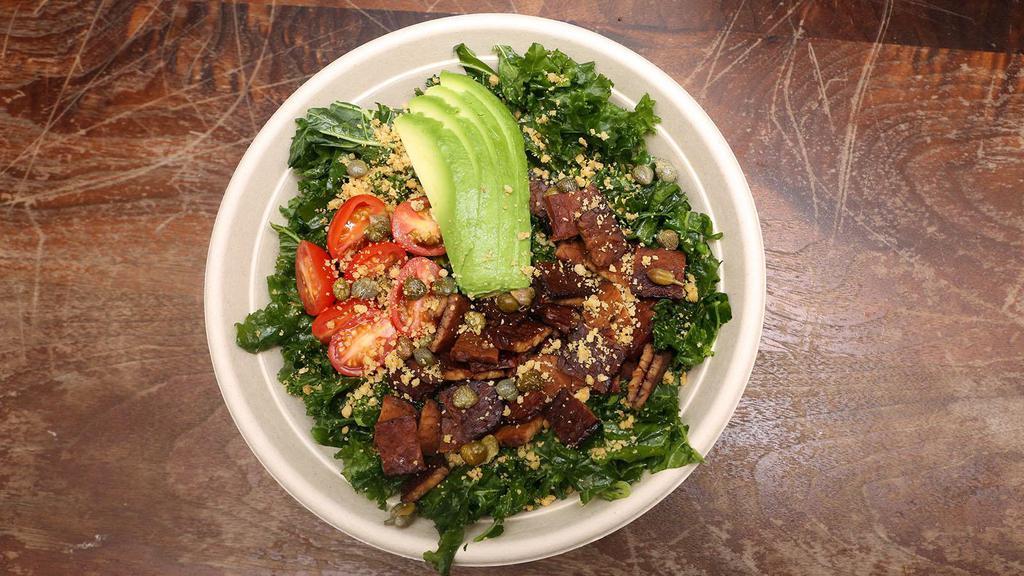 The Les Kale Caesar Salad · Chopped kale massaged with lemon juice and olive oil, topped with tempeh bacon, cherry tomatoes, capers, avocado and walnut parmesan. served with a side of cashew caesar dressing and house made croutons.