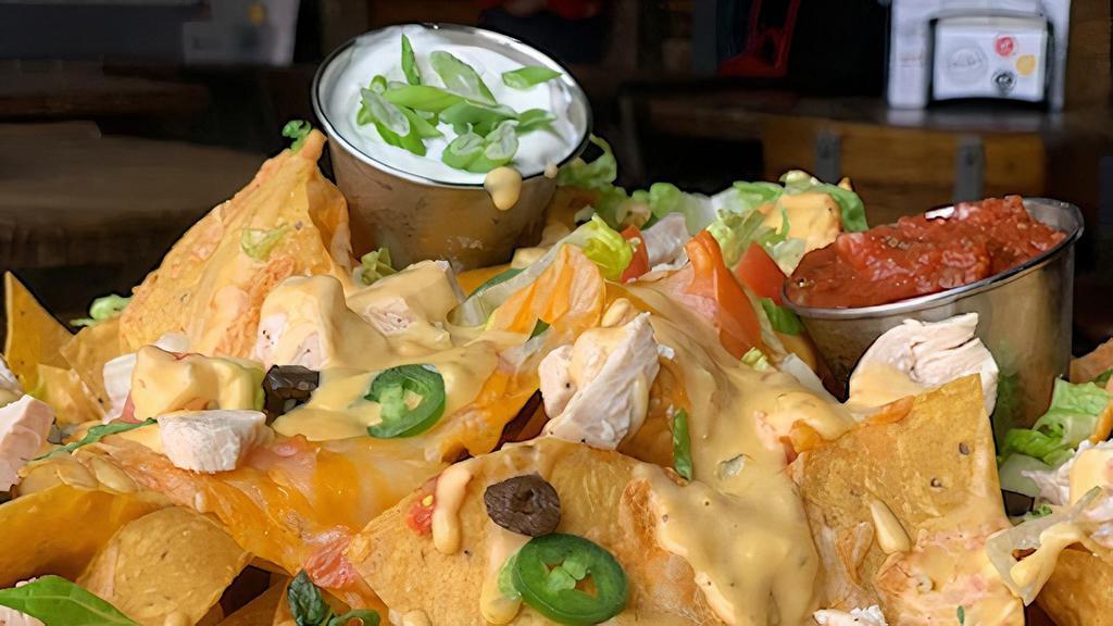 Hooligans Nachos · A heaping portion of homemade tortilla chips, Cheddar jack cheese, black olives, jalapeños, tomatoes, white onion, and lettuce. Drizzled with our jalapeño Cheddar sauce. Served with sour cream and salsa. Add more items at an upcharge.