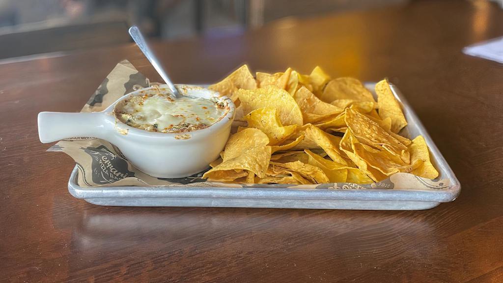 Spinach Artichoke Dip · A 90 s throwback! But this isn’t your average spin dip. Spinach and artichokes baked to bubbling in garlic parmesan fondue. Served with tortilla chips for dipping.