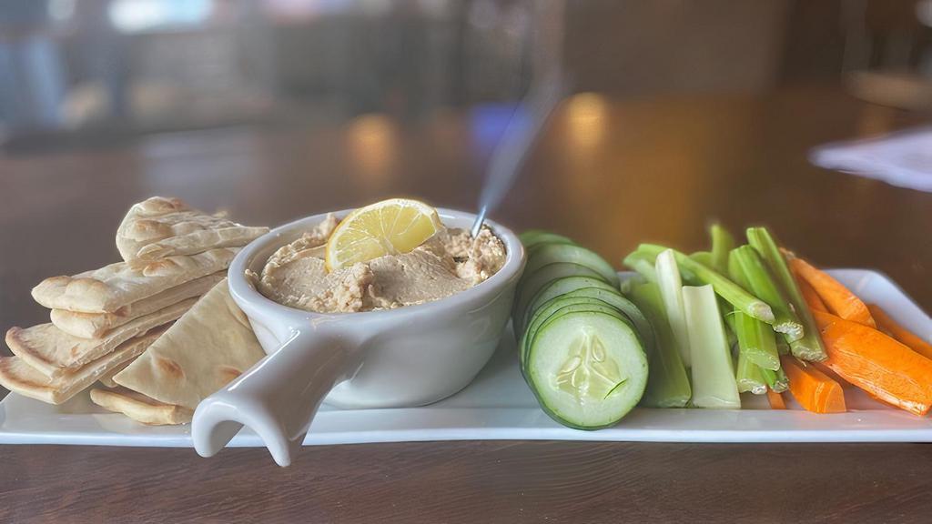 Hummus · Fresh hummus served with cucumber, carrots, celery, and warm grilled pita wedges.