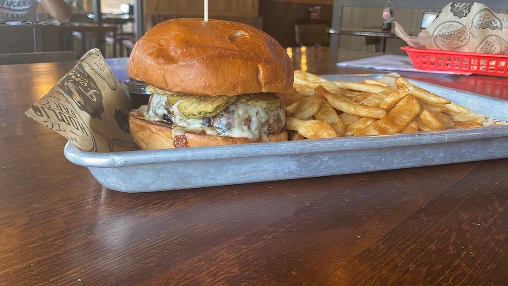 Frickle Burger · Topped with our fried pickle chips, sliced red onion, Monterey jack cheese, and topped with garlic aioli. Served “pink or no pink” with French fries.
