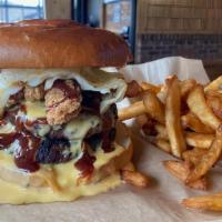 The Hooligan Burger · Two beef patties layered with bacon, chicken tenders, cheese sauce a fried Hooligan burger e...
