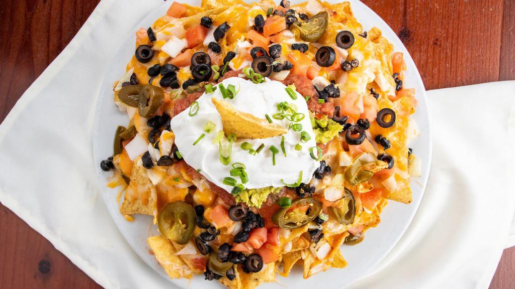 Beachboy Nachos · corn tortilla chips topped with fresh diced tomatoes, onions, black olives, jalapenos, black beans, melted shredded cheese, guacamole, sour cream, salsa, & your choice of kalua pork, chicken, or ground beef