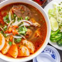 Bun Bo Hue · Spicy. A spicy lemongrass beef noodle soup with brisket, Vietnamese ham (cha lua), and pork ...