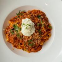 Pappardelle Bolognese · Classic meat ragu, fresh herbs, ricotta cheese.