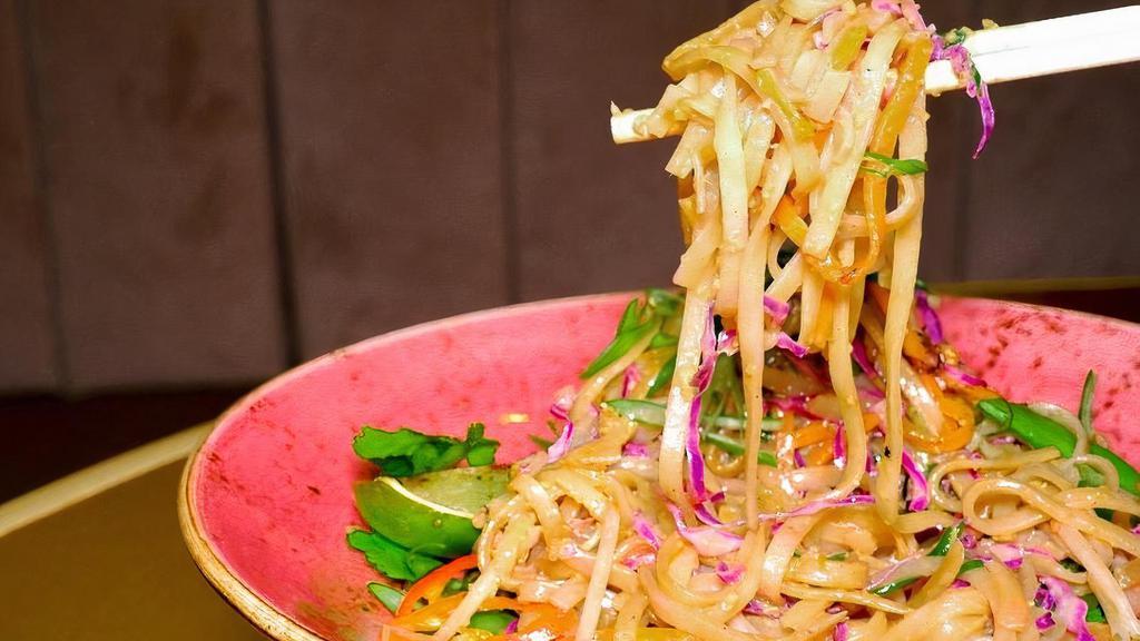Peanut Street Noodles (Gf, V) · Stir fried in peanut sauce, sugar snap peas, red cabbage, bean sprouts, red chilies, scallions, crushed peanuts, sesame seeds, cilantro served with charred lime.