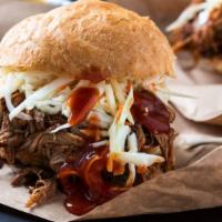 Pulled Pork Sandwich · Delicious Chicken sandwich topped with Pulled Pork, sharp cheddar, and red cabbage slaw on a...
