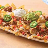 Neighborhood Nachos Beef · Freshly made white corn tortilla chips are topped with taco-seasoned ground beef, queso blan...